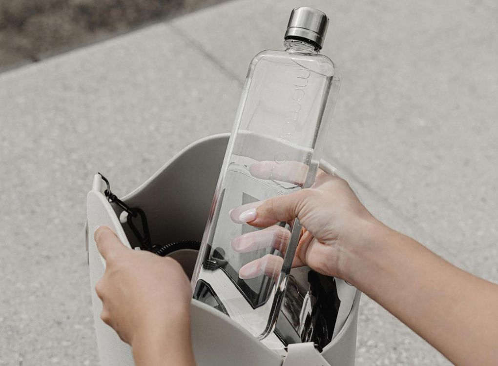 Original clear memobottle in Slim being put into a backpack