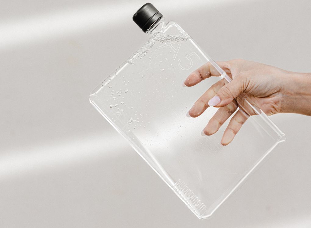 Original clear memobottle in A5 full of water being carried by hand