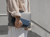 Navy blue memobottle in slim being carried with a laptop